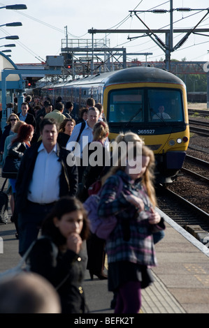 Les passagers de la gare de Cambridge platorm l'attente comme un train tire dans Banque D'Images