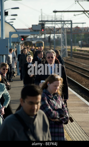 Les passagers de la gare de Cambridge platorm en attente pour le prochain train. Banque D'Images