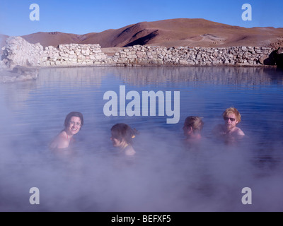 Les touristes dans les sources thermales du Tatio Geysers dans le désert d'Atacama, au Chili. Banque D'Images