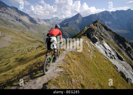 Un vélo de montagne monte un sentier sur une crête près de Les Arcs dans les Alpes françaises. Banque D'Images