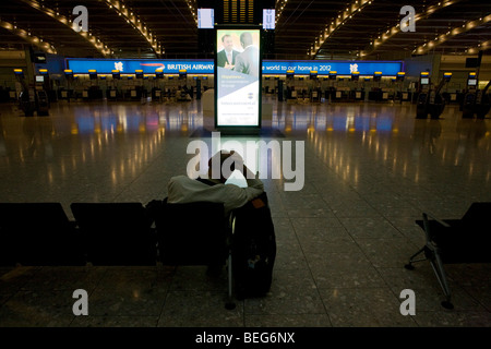 Passagers bloqués vous attend prochain vol le matin à partir d'un hall de départ vide à Heathrow Terminal 5. Banque D'Images