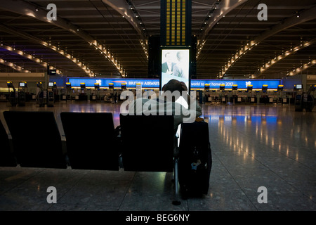 Passagers bloqués vous attend prochain vol le matin à partir d'un hall de départ vide à Heathrow Terminal 5. Banque D'Images