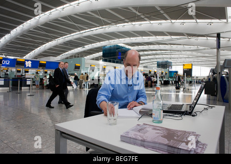 L'écrivaine en résidence, Alain de Botton écrit son roman dans l'aéroport de départ à l'aéroport d'Heathrow Terminal 5. Banque D'Images