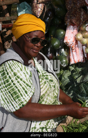 Femme africaine écosser les haricots sur son étal de fruits et légumes à Mbabane, Swaziland Banque D'Images
