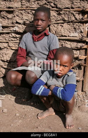 Deux jeunes enfants assis à l'extérieur leur Zoulou Accueil prises dans la province de KwaZulu-Natal, Afrique du Sud Banque D'Images