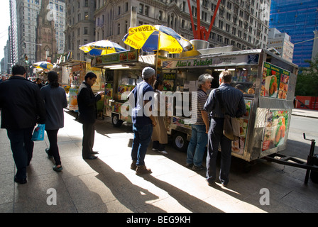 Diners de pays du Moyen-Orient et d'autres aliments de rue à Broadway dans Lower Manahttan à New York Banque D'Images