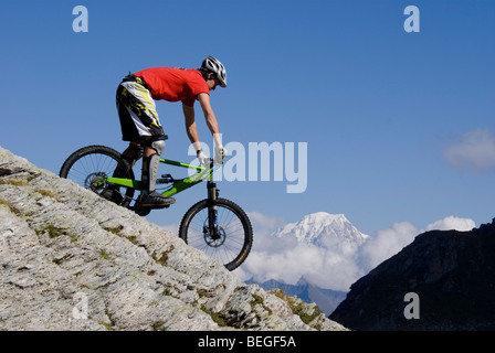 Un vélo de montagne vers le bas en une pente rocheuse dans Les Arcs dans les Alpes françaises, avec le Mont Blanc en arrière-plan. Banque D'Images
