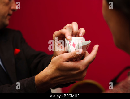 Un Magicien Close up faisant des tours de carte à une réception de mariage parti, UK Banque D'Images