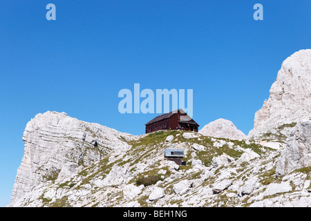 La cabane de montagne, Zasavska Koca na Prehodavcih Triglav, avec au loin, les Alpes Juliennes, en Slovénie. Banque D'Images