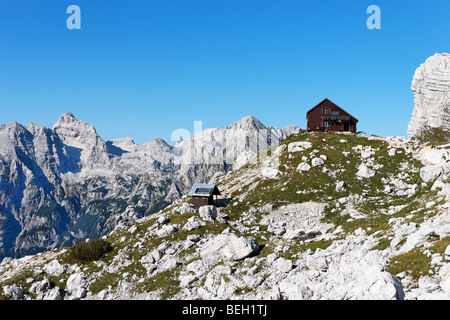 La cabane de montagne, Zasavska Koca na Prehodavcih rasoir, avec au loin, les Alpes Juliennes, en Slovénie. Banque D'Images