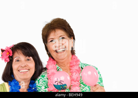 Portrait of a senior woman smiling maracas et son amie à côté d'elle Banque D'Images