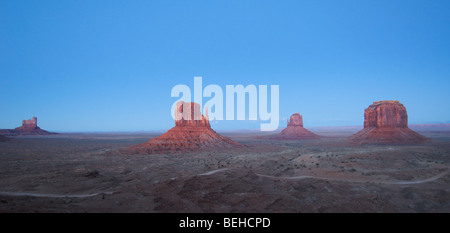 Monument Valley pendant le lever du soleil, avec du ciel bleu et de pierres rouges. Banque D'Images