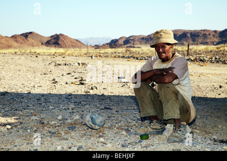 L'homme, de la Namibie Namibie homme assis au bord de la route Banque D'Images