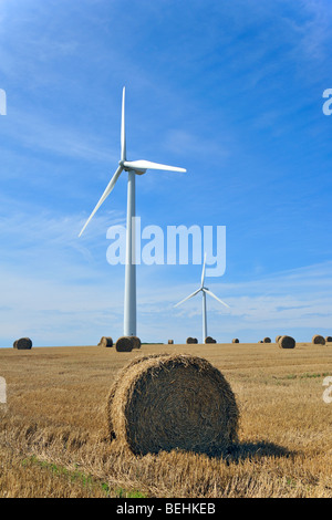 Éoliennes dans le champ fauché avec hay bales Banque D'Images