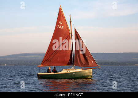 La voile autour de port de Poole dans un Cornish Shrimper bateau en été Banque D'Images