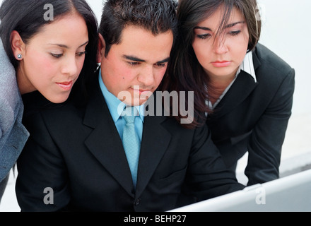 Close-up of a businessman and two businesswomen looking at a laptop Banque D'Images