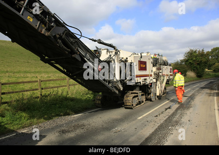 Le décapage du revêtement routier de la machine en action sur une route de campagne. Banque D'Images