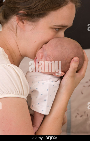 Mère de câlins et baisers baby boy, 11 semaines Banque D'Images