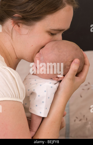 Mère de câlins et baisers baby boy, 11 semaines Banque D'Images