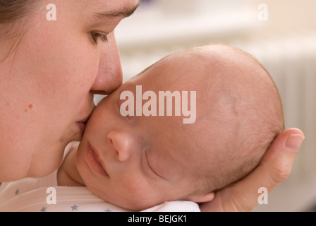 Gros plan d'une mère de câlins et baisers baby boy, 11 semaines Banque D'Images