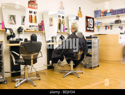 Un homme en attente d'une coupe de cheveux à un salon de coiffure en France Banque D'Images