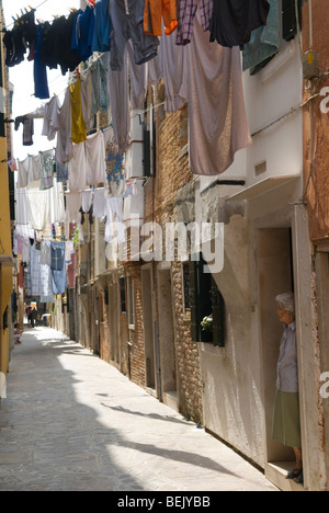 Clothesline famille lavant le linge traînant pour sécher, lignes de vêtements publics à travers la rue étroite. Logement public. Arsenale, Venise Italie années 2000 2010 Banque D'Images