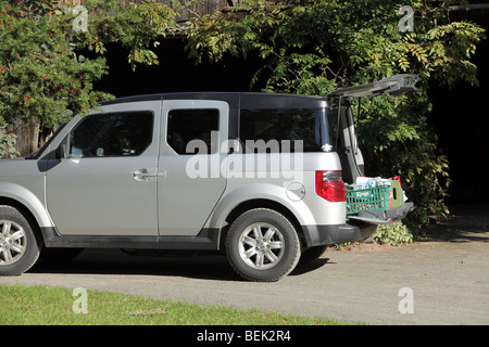 Honda Element un VUS avec l'arrière de l'écoutille est ouverte et les boîtes assis sur l'ascenseur entrée, prêts à être chargés ou déchargés. Banque D'Images