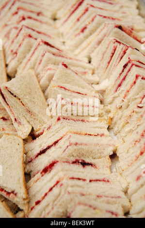 Beaucoup de couper le pain blanc ou de fraises Confiture de framboises sandwichs triangulaires prêt pour une fête d'anniversaire de childs Banque D'Images