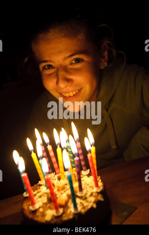 Quinze ans Welsh teenage girl blowing out les bougies sur son gâteau d'anniversaire, UK Banque D'Images