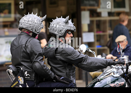 Motocycliste et passager portant un casque à cornes Banque D'Images