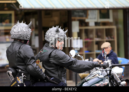 Motocycliste et passager portant un casque à cornes Banque D'Images