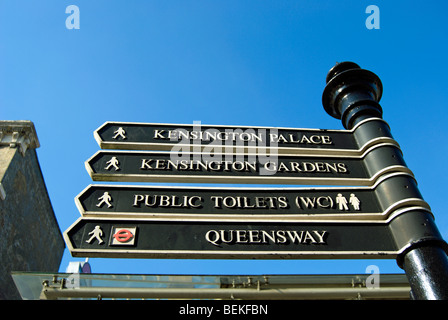 Panneau de Queensway, Londres Angleterre, donnant des directives à Kensington Palace, Kensington Gardens, et les toilettes publiques ou wc Banque D'Images