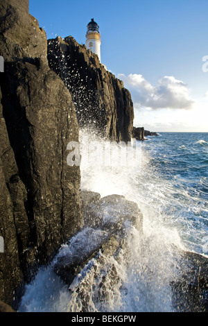 Neist Point Lighthouse avec martèlement des vagues contre les rochers au premier plan, l'île de Skye, en Ecosse Banque D'Images