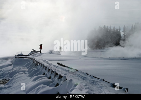 Sentier de la promenade sur les visiteurs dans le brouillard à West Thumb dans le Parc National de Yellowstone en hiver. Banque D'Images