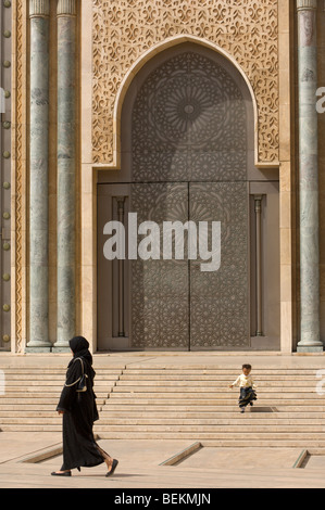 Une petite fille court marocain en descendant une volée de marches dans la cour de la Mosquée Hassan II, Casablanca, Maroc, Afrique Banque D'Images