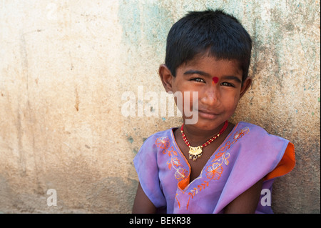 Jeune Indien street girl smiling appuyé contre un mur dans l'Inde, avec l'exemplaire de l'espace. Banque D'Images