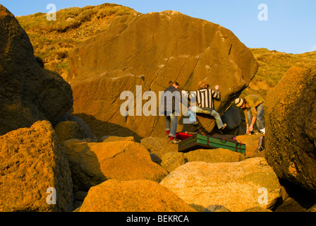 Les grimpeurs bouldering en hiver le soleil l'après-midi à Porth, Ysgo au Pays de Galles Banque D'Images