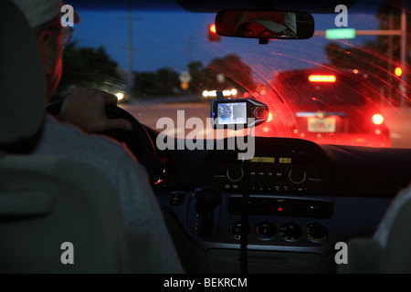 Vue de l'intérieur et à l'extérieur le pare-brise d'une voiture, dans la circulation, de nuit. Banque D'Images