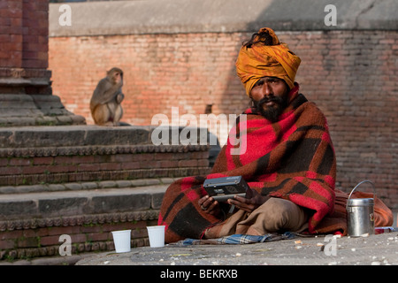 Pashupatinath, Népal. Sadhu (saint homme) et sa Radio au Népal's Holiest Temple Hindou. Banque D'Images