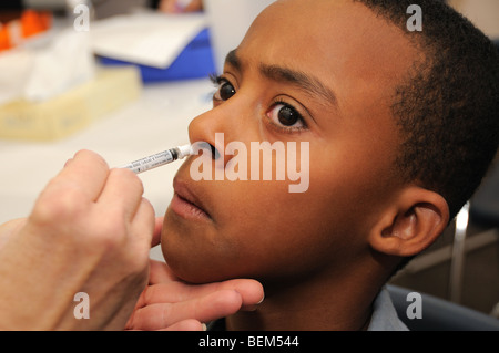 Un garçon de 10 ans est vacciné pour la grippe H1N1, aussi connu sous le nom de la grippe porcine, avec un vaccin intranasal. Banque D'Images