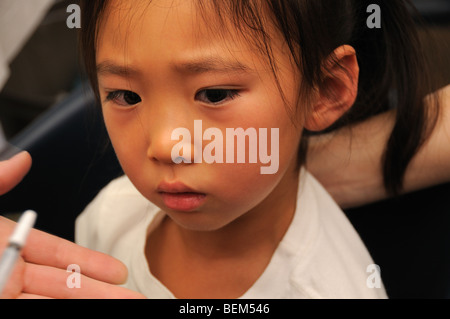 Une fillette de cinq ans est vacciné pour la grippe H1N1, aussi connu sous le nom de la grippe porcine, avec un vaccin intranasal. Banque D'Images