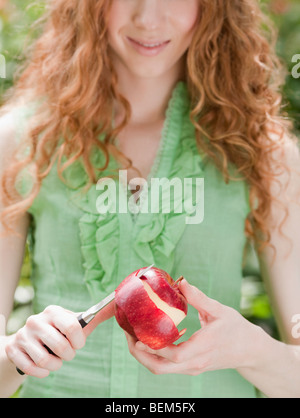 Woman peeling apple Banque D'Images