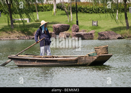 L'homme dans un vieux bateau en bois dans une rivière de Xitang Xitang est une ancienne ville pittoresque à Jiashan County, Province de Zhejiang, Chine. Banque D'Images