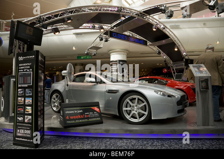 Stand de la concurrence pour une voiture de luxe super tirage au sort dans la salle d'embarquement du terminal sud. L'aéroport de Gatwick. Londres. UK. Banque D'Images