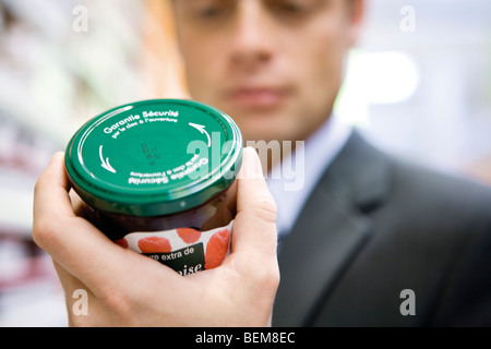 Man reading label sur pot de confiture Banque D'Images