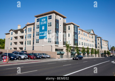 Un panneau publicitaire sur un nouveau bâtiment à utilisation mixte par une route. Broadway Park, El Camino Real de Millbrae, CA, USA Banque D'Images