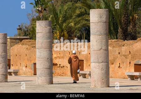 Un visiteur marche au milieu des colonnes de la salle de prière de la mosquée Hassan inachevé, Rabat, Maroc, Afrique. Banque D'Images