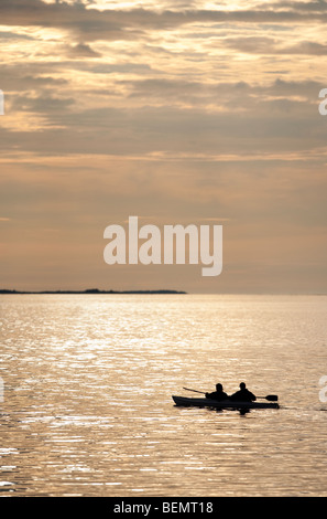 Deux hommes kayak en mer au coucher du soleil , Finlande Banque D'Images