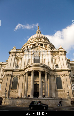 Une cabine London noir passe la façade de la Cathédrale St Paul, au centre de Londres. Banque D'Images