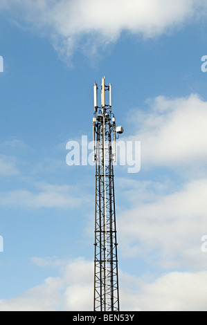 Un mât de téléphonie mobile contre un ciel bleu dans une zone résidentielle Banque D'Images